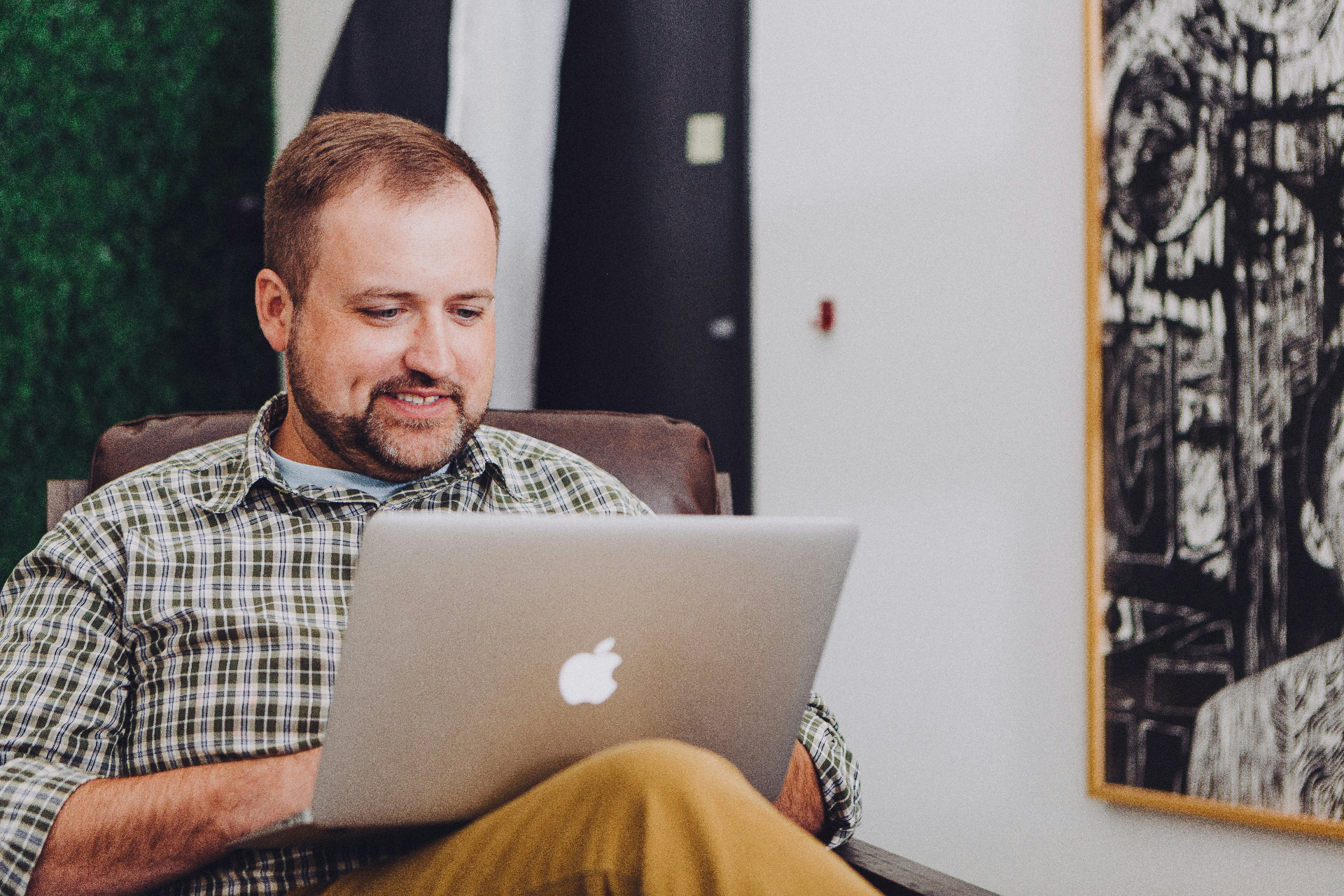 Homeowner relaxed in an armchair using Home Folio on a laptop